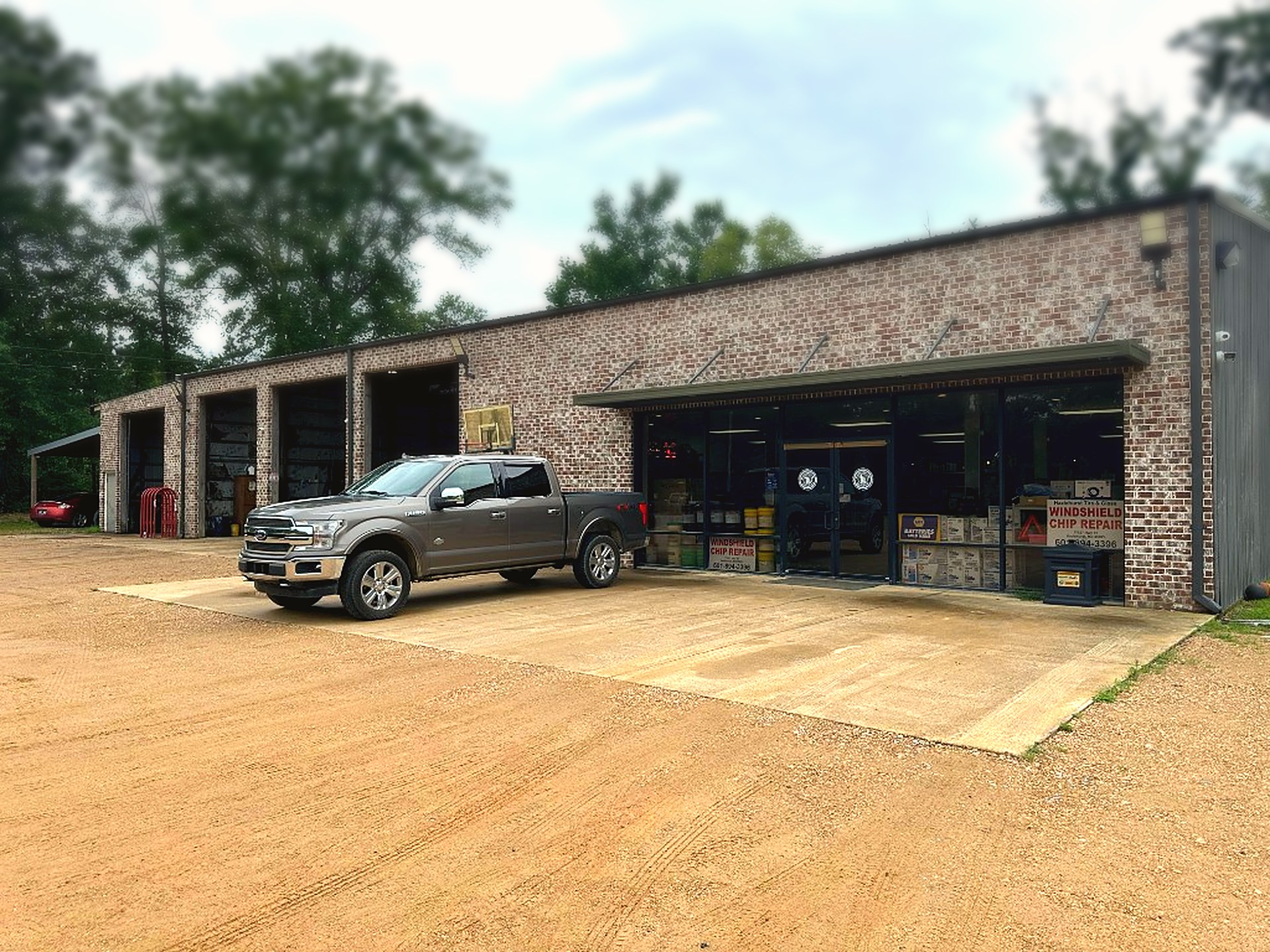 Hazlehurst Tire Company storefront in Hazlehurst, MS — brick shop, service bays, and a customer truck out front.